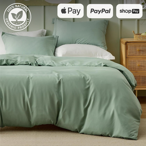 Sage green bedding set with white sheets on a bed near a wooden nightstand, showcasing payment options like Apple Pay, PayPal, and Shop Pay.