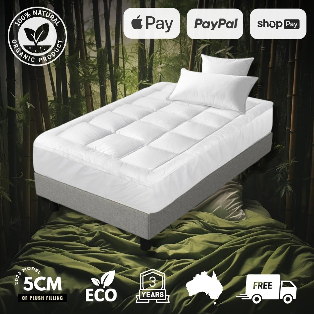 Image showcasing a luxurious bamboo mattress topper on a bed, highlighted against a bamboo forest background. The mattress topper is labeled with icons for 100% natural organic product, eco-friendly, 5cm plush filling, 3 years warranty, made in Australia, and free shipping. Payment options include Apple Pay, PayPal, and Shop Pay