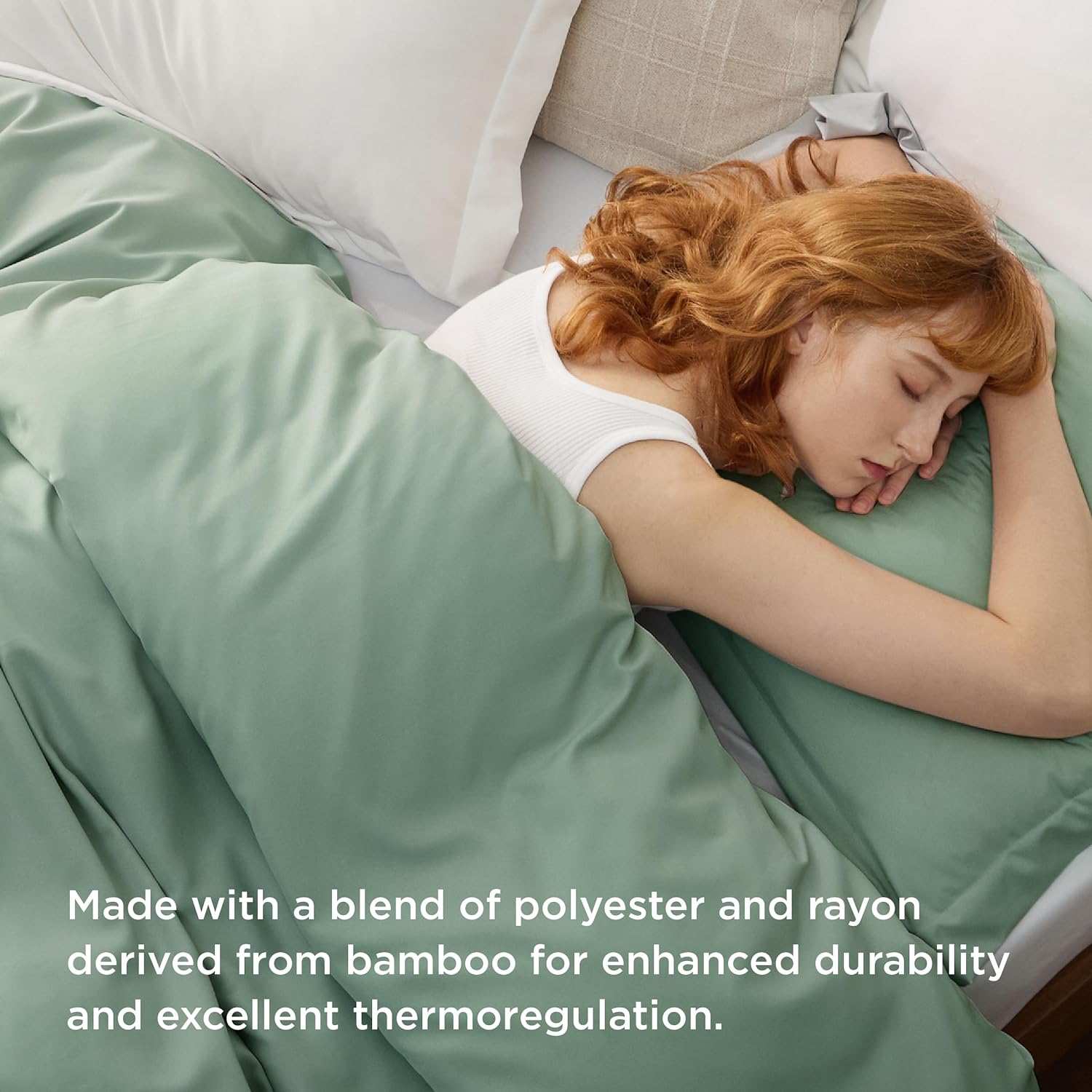 Red-haired woman sleeping under a sage green bamboo blend comforter, emphasizing durability and thermoregulation benefits.