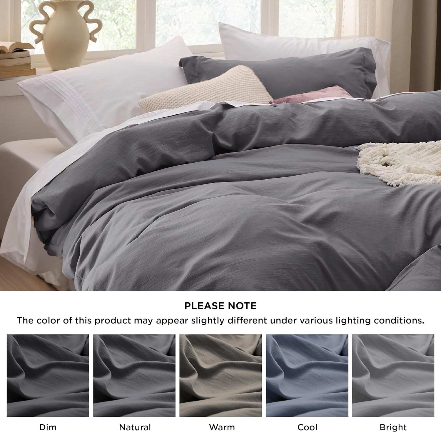 Charcoal bedding with white and pink accents, natural light, and color variation note, cozy decor with vase and window.