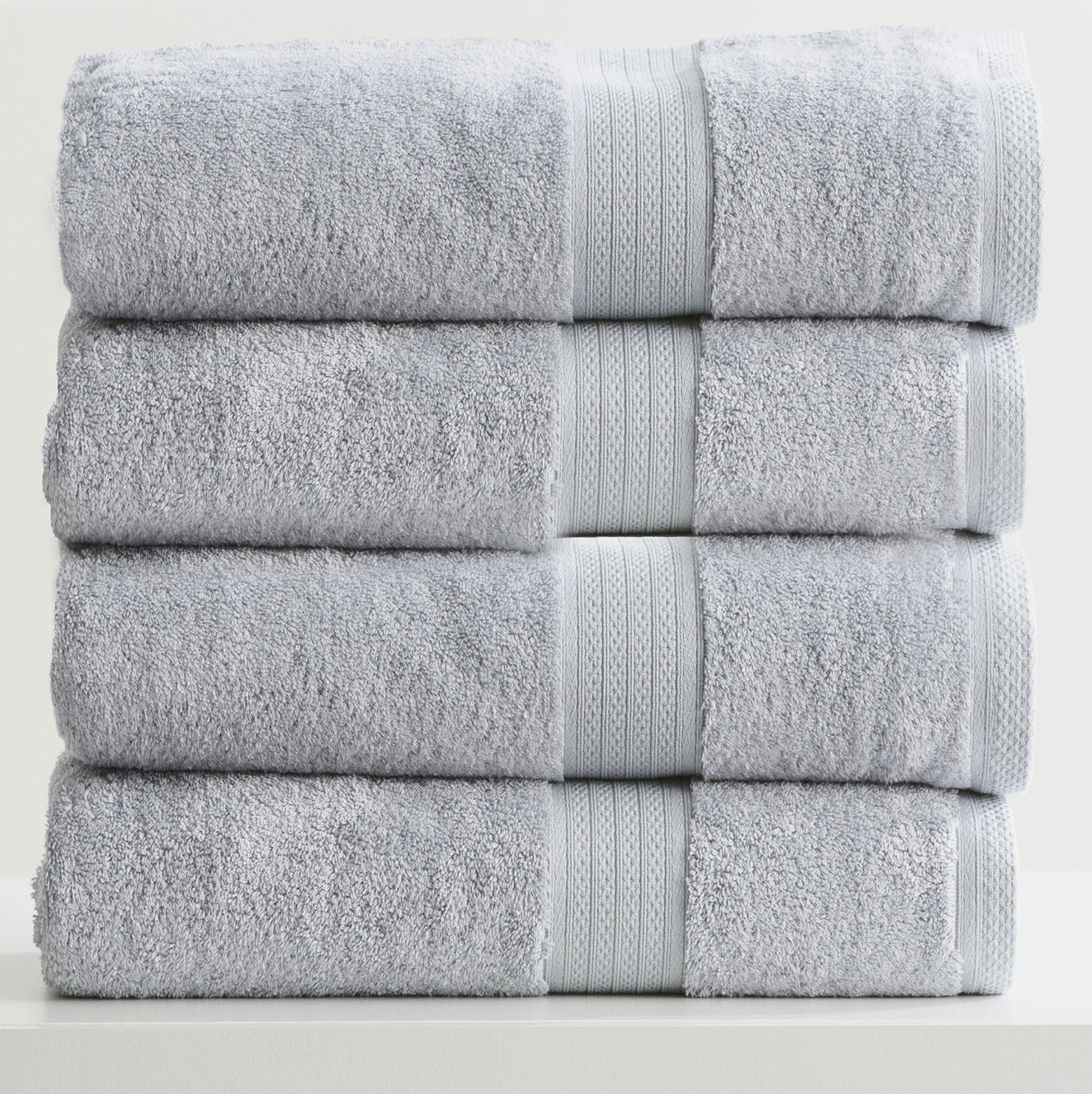 Stack of Adorearth™ organic bamboo towels in light gray color, showcasing soft and eco-friendly bathroom essentials.