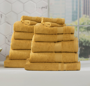 Adorearth™ organic bamboo towels in mustard color stacked in a modern bathroom setting.