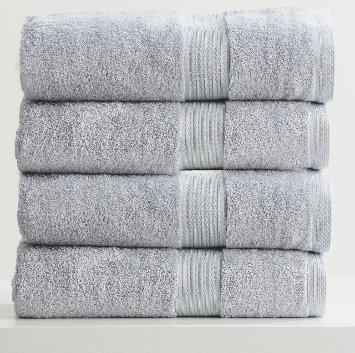 Stack of four folded Adorearth™ organic bamboo towels in light gray