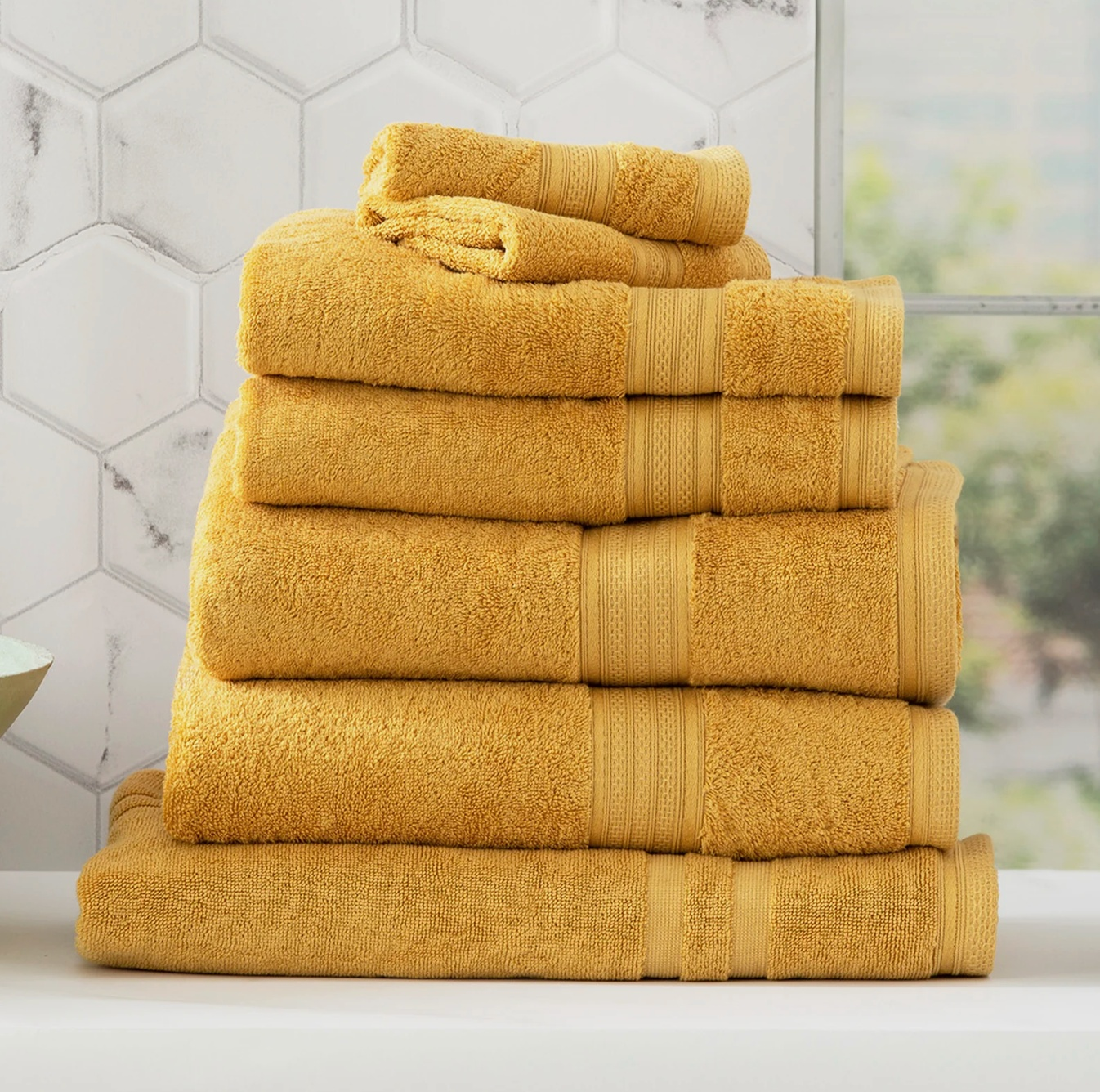 Stack of Adorearth™ Organic Bamboo Towels in yellow on a bathroom counter