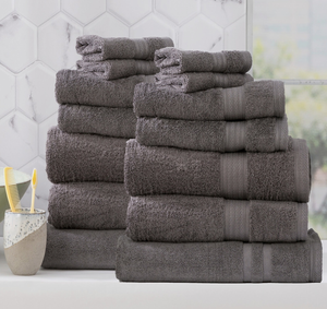 Adorearth™ organic bamboo towels in gray, neatly stacked in bathroom setting with a toothbrush holder in the background