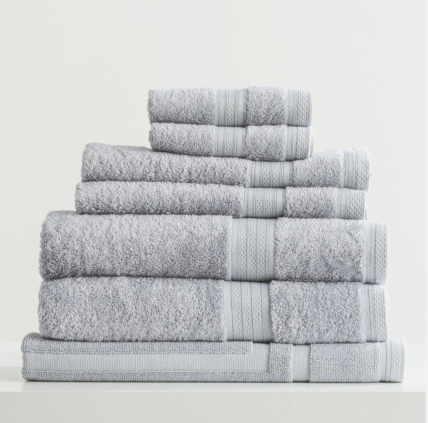 Stack of Adorearth™ organic bamboo towels in light gray color.